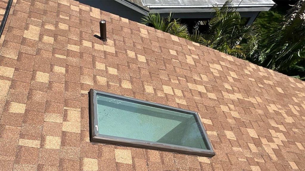 A roof with a glass skylight, designed to enhance natural lighting in the building