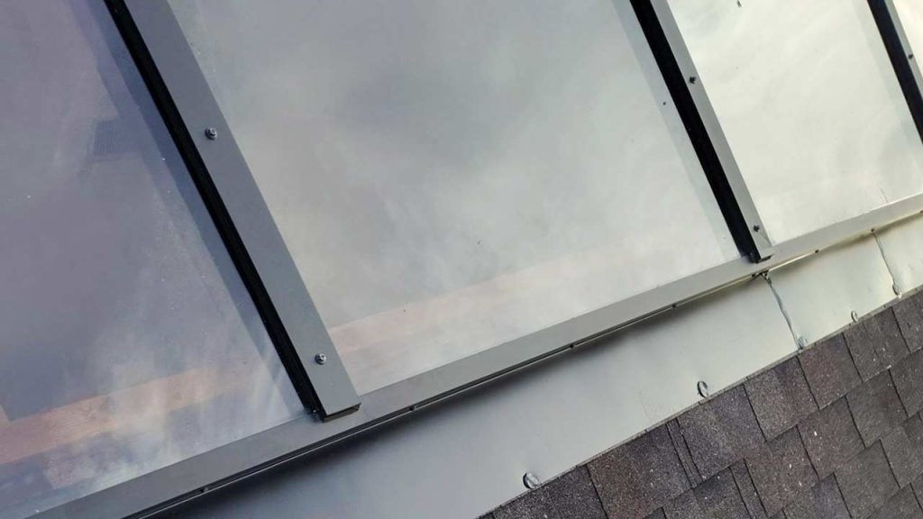 American Skylights ridge-mount frame detailing on a residential shingle roof installation in Florida.