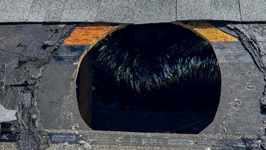 Roof deck opening cut for an Attic Breeze solar attic vent installation