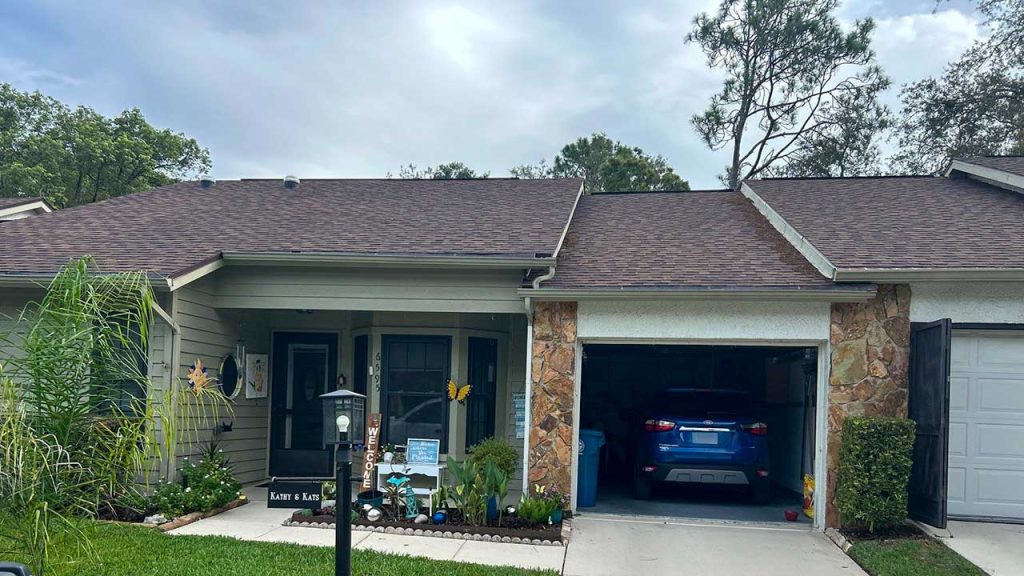 Installed VELUX TMR 010 Sun Tunnel on the asphalt shingle roof of a single-family home with a two-car garage.