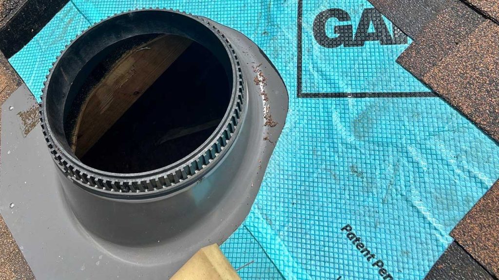 Roofing detail showing the initial installation step of a VELUX TMR 010 Sun Tunnel flashing collar integrated with roof underlayment and shingle courses.