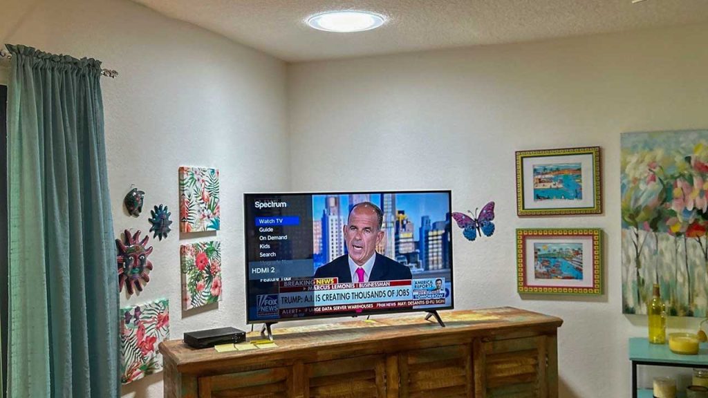 Bright interior illumination on a home media setup provided by a newly installed VELUX TMR 010 Sun Tunnel skylight.